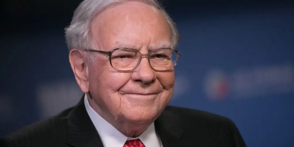 A portrait picture of Warren Buffett smiling in a suit