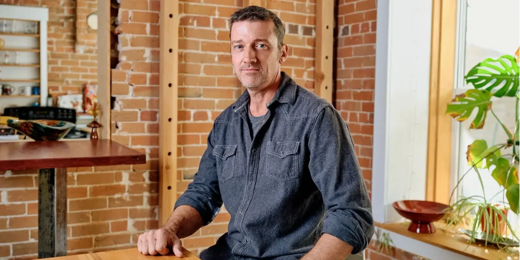A portrait picture of pete adeney sitting at a table.